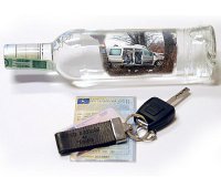 Butelka po alkoholu, a przy  niej samochodowe kluczyki.