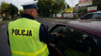Policjant bada trzeźwość kierowcy samochodu osobowego