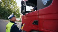 Policjant bada stan trzeźwości kierowcy samochodu ciężarowego