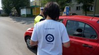 Policjant myszkowskiej drogówki wspólnie z wolontariuszką Fundacji PZU rozdają serduszka z logo kampanii: Kochasz? Powiedz STOP Wariatom Drogowym&quot;