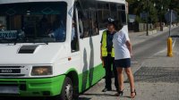 Policjant z wolontariuszką wręczają kierowcy busa symboliczne zapachowe serduszko