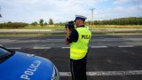 Policjant ruchu drogowego za pomocą Laserowego Miernika Prędkości sprawdza jak szybko jeżdżą kierowcy