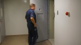 Policjant otwiera drzwi pomieszczenia dla zatrzymanych