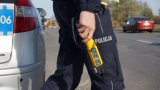Policjant trzyma w ręce urządzenie do badania stanu trzeźwości