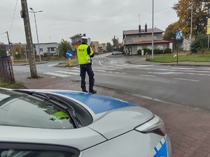 Na zdjęciu policjant duchu drogowego stojący przy pasach dla pieszych